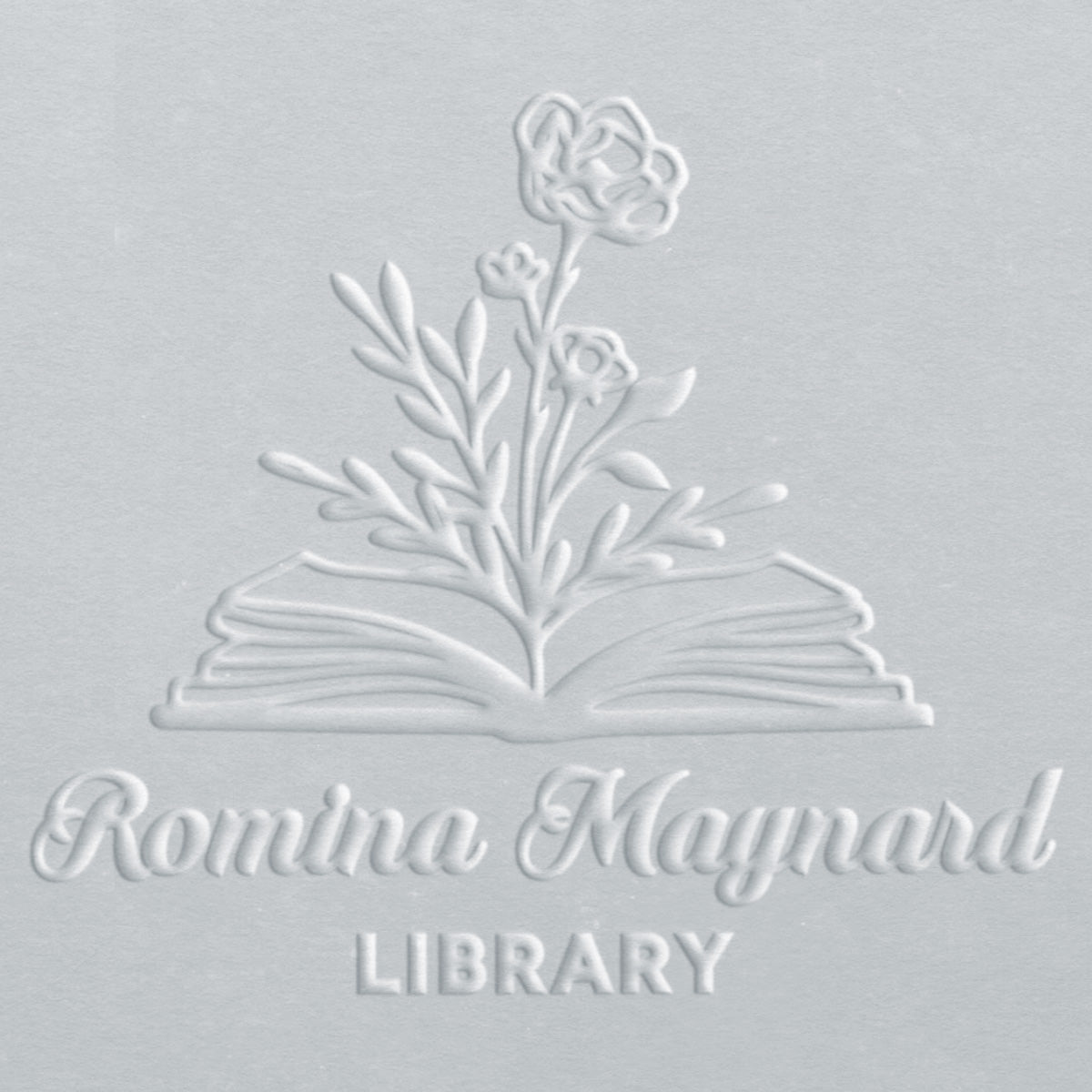 Embossed design of an open book with flowers on a light gray background, featuring the text 'Romina Maynard Library'.