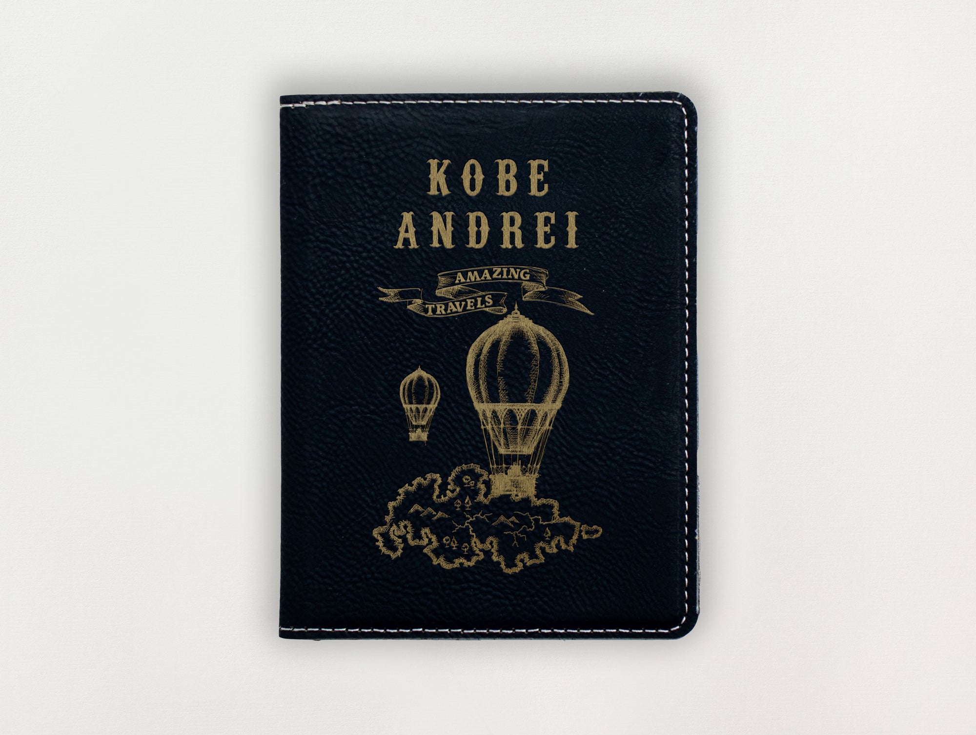 Black passport holder with gold text and hot air balloon design